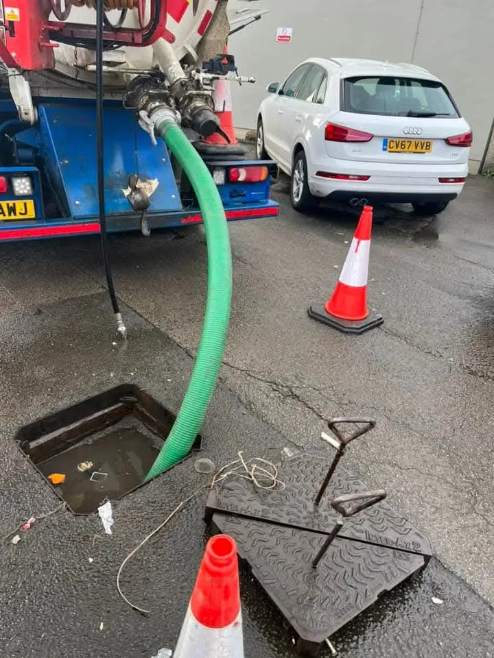 Drain King engineers clearing a blocked manhole during a drainage job.
